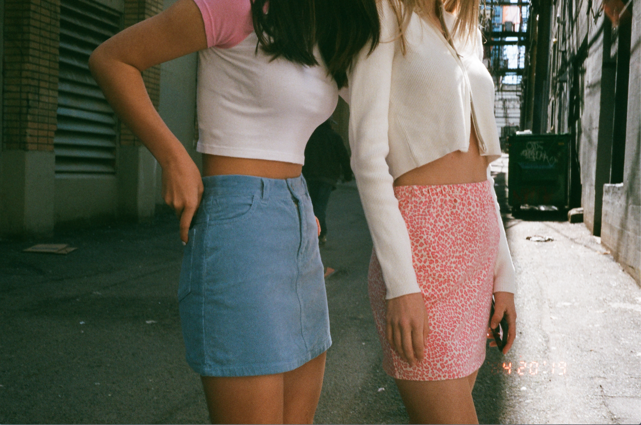 two people modeling clothing in an alleyway